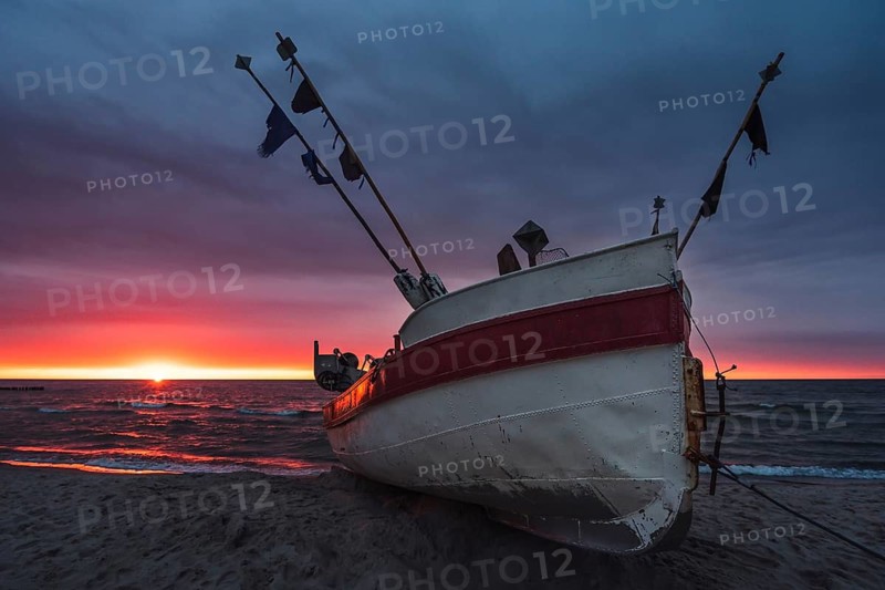 Fishing boat on the beach at sunset. Baltic sea
