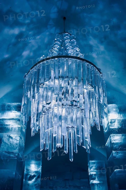 A mesmerizing ice chandelier with crystal-like shapes illuminates the temporary ice hotel in Swedish Lapland, showcasing exquisite craftsmanship