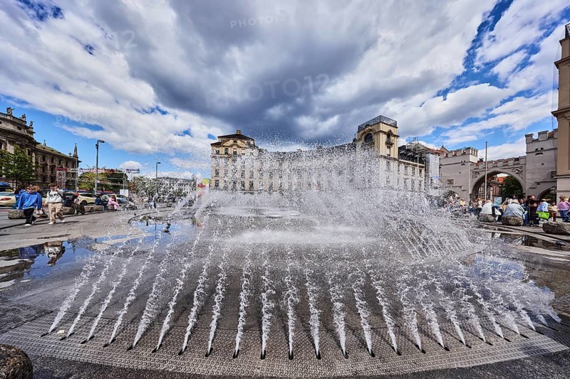 Fountain, water fountain, frozen movement, general architecture, residential and commercial buildings, Stachus roundel, neo-baroque style, pedestrian zone, square, pedestrian as a secondary motif, blue sky, white and dark gray cumulus clouds, Stachus, Karlsplatz, Munich, state capital, district-free city, Bavaria, Germany
