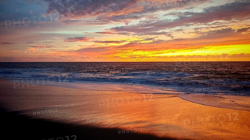 Sunset with dramatic sky and shimmering sand on the tranquil seashore, Tarrafal de Monte Trigo, Santo Antao, Cabo Verde, Cape Verde
