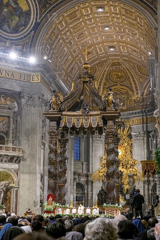 Catholic Church leader Pope with mitre Saint Father celebrates Mass in St. Peter's Basilica in front of Bernini's canopy under St. Peter's Basilica dome in the foreground believing Christians at devotion church service, Vatican, Rome, Italy
