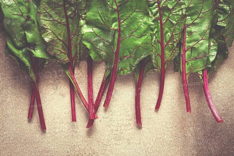 Fresh, green leaves, stem with beet leaves, on the table, top view, rustic, no people