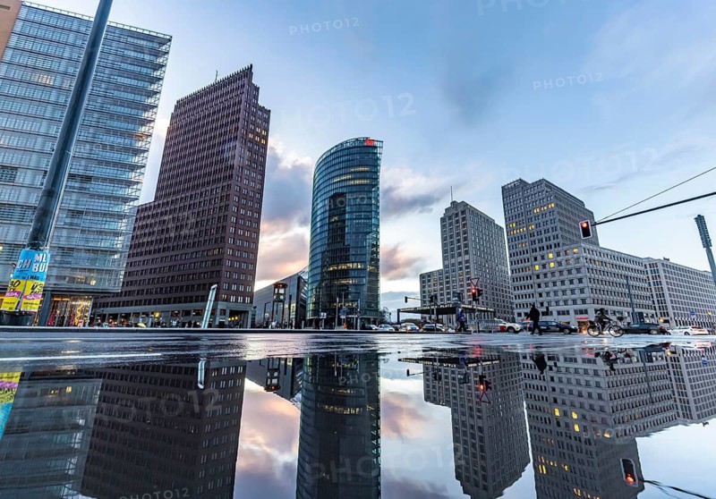 Potsdamer Platz Berlin in the evening with traffic on the streets. When it rains, the skyscrapers are reflected in puddles of water. Berlin, Germany