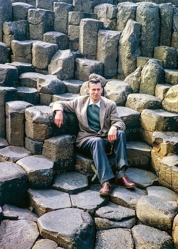 Man sitting on basalt columns at the Giant's Causeway, County Antrim, Northern Ireland, United Kingdom around 1960