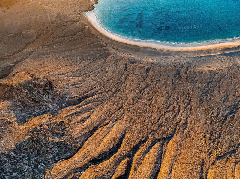 Cliff and beach with blue sea in evening light, top-down shot, near Mirador del Porrito, aerial view, at sunset, Lanzarote, Canary Islands, Spain