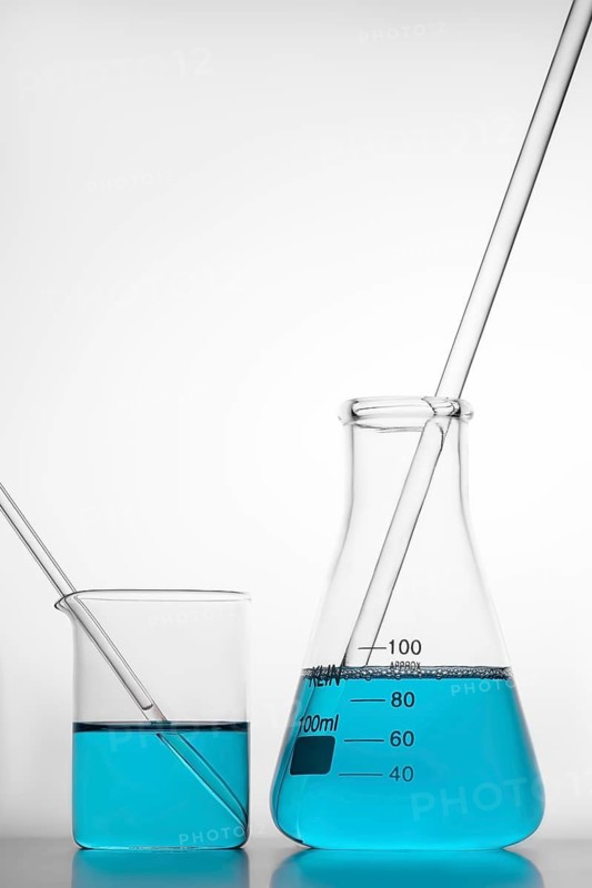 A beaker and flask containing blue liquid with stirring rods, symbolizing laboratory experiments and research. Perfect for representing science and chemistry themes