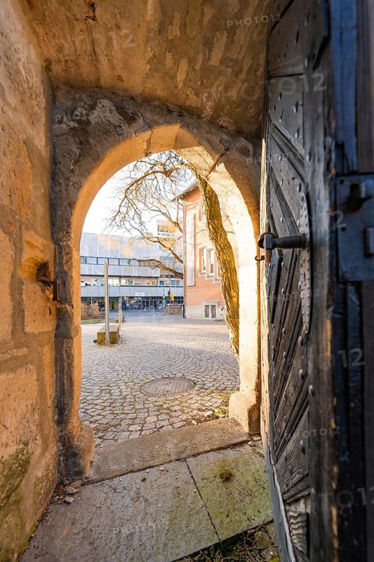 View through an old stone gate onto a cobbled courtyard in warm light, Sindelfingen, Böblingen district, Germany