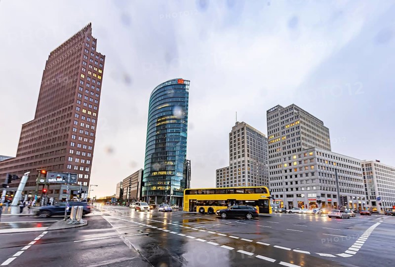 Potsdamer Platz Berlin in the evening with traffic on the streets. When it rains, the skyscrapers are reflected in puddles of water. BFG double-decker bus. Berlin, Germany