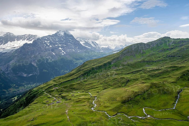 View of mountain landscape with green meadows and alpine huts Bachlager, Grindelwald First, snow-capped Eiger mountain peak, Grindelwald, Bernese Alps, Bernese Oberland, Switzerland