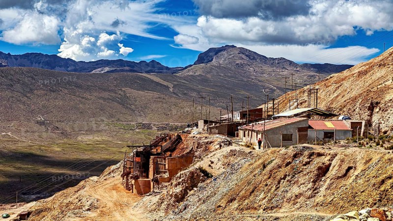 Mountainous landscape with buildings and wide sky under dramatic clouds, The silver mines near Potosi on Cerro Rico in Bolivia