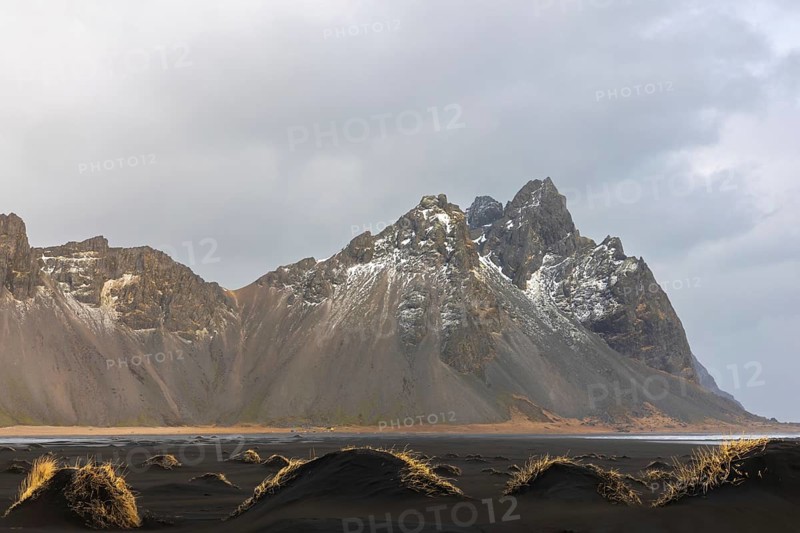 Sand dunes covered with rotten grass, lava sandy beach against mountain backdrop, winter, Stokksnes, Vestrahorn, Klifatindur, Höfn, Iceland, Scandinavia