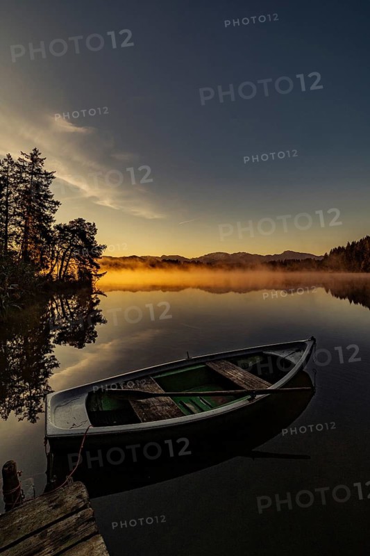 Boats in the autumnal Schmutter Weiher in the Allgäu near the municipalities of Halblech, Roßhaupten and Lechbruck in Ostallgäu in the foothills of the Alps