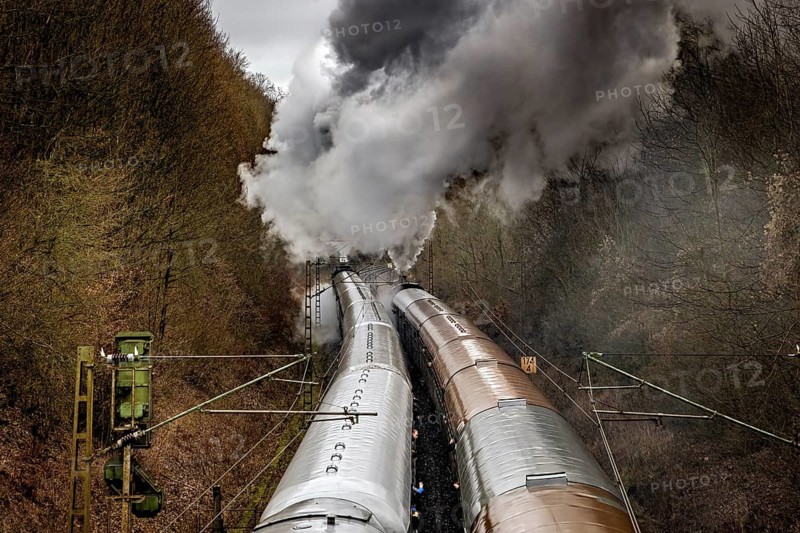 Black steam locomotive moves through wooded mystical route with powerful smoke, historic steam locomotive ride between Bebra and Sontra