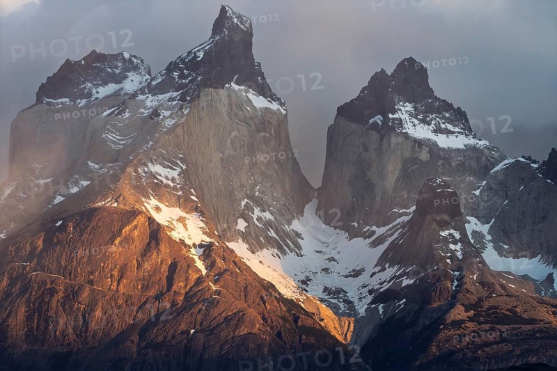 Cuernos del Paine, granite peaks with snow in the morning light, clouds moving around the rock walls, Torres del Paine National Park, Patagonia, Chile