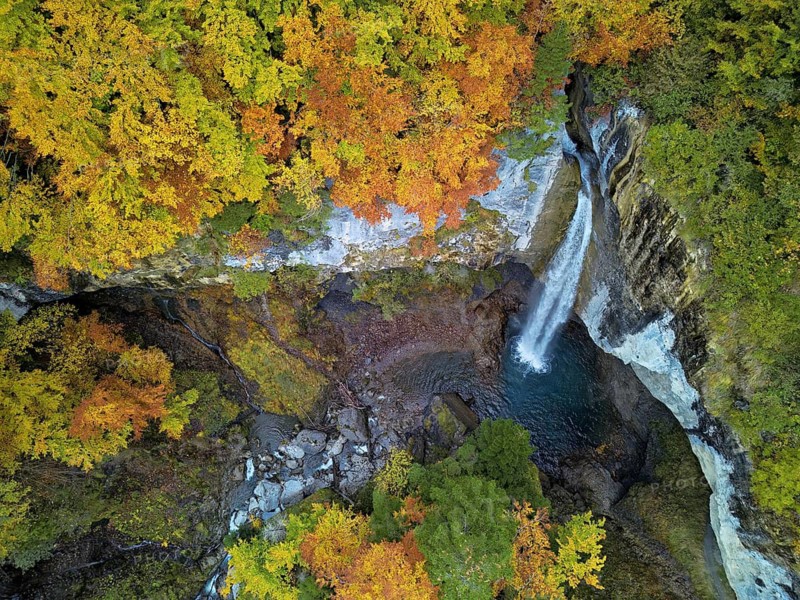 Aerial view of Berglistüber waterfall in autumn-colored surroundings, Linthal, Klausenpass, Canton of Glarus, Switzerland