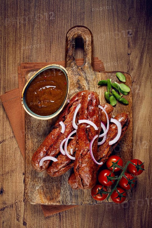 Fried sausages, in English with bacon, for grilling, on a cutting board, top view, no people