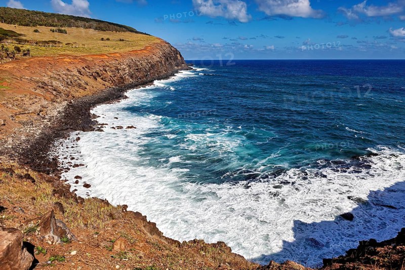 Cliff coast with foaming waves and blue sky, the landscape of Easter Island in the Pacific Ocean