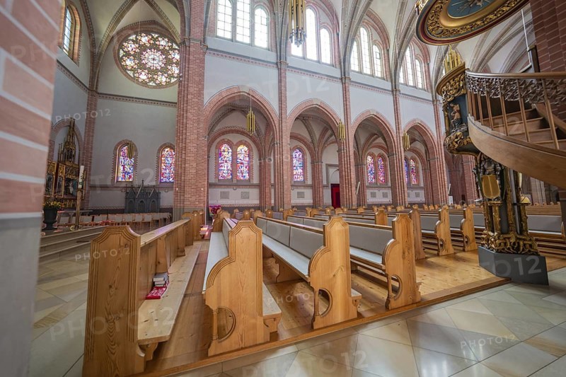 Church interior with wooden benches, colorful windows and a decorated pulpit, Sacred Heart, Bregenz, Austria