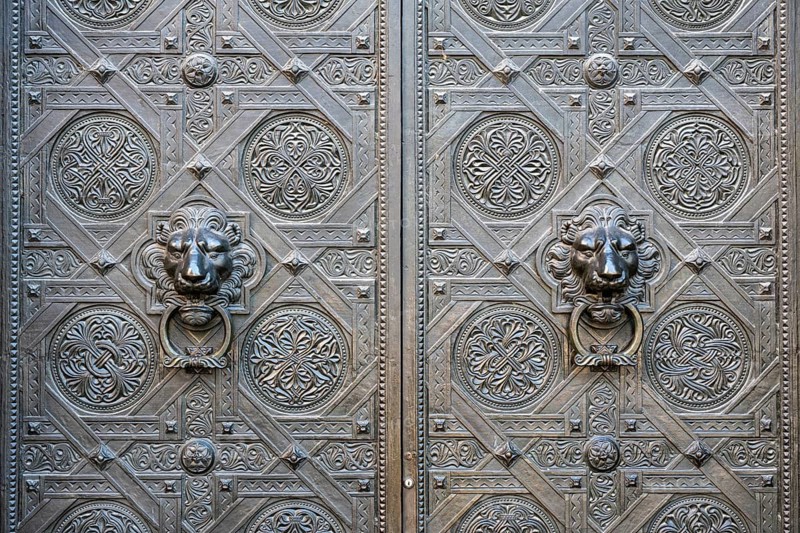 Artfully decorated bronze doors with lion heads as door pullers or door knockers on the Gallus portal at the northern transept of Basel Cathedral, Old Town, Basel, Canton of Basel-Stadt, Switzerland