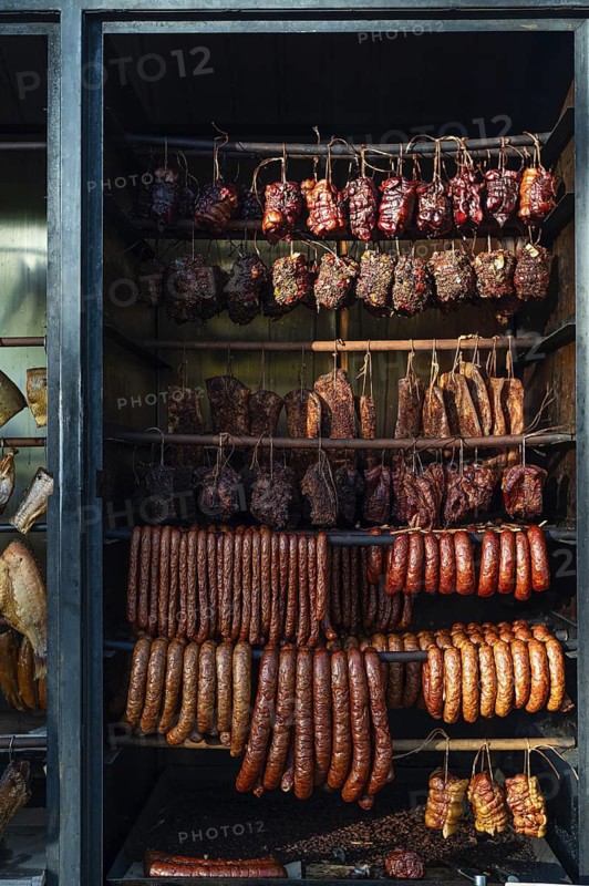 Meat and sausage hanging in a traditional wood-fired smokehouse