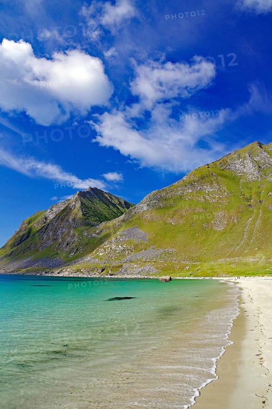 A secluded sandy beach meets turquoise blue sea under picturesque hills and sky, Haukland, Leknes, Vestvågøya, Lofoten, Nordland, Norway