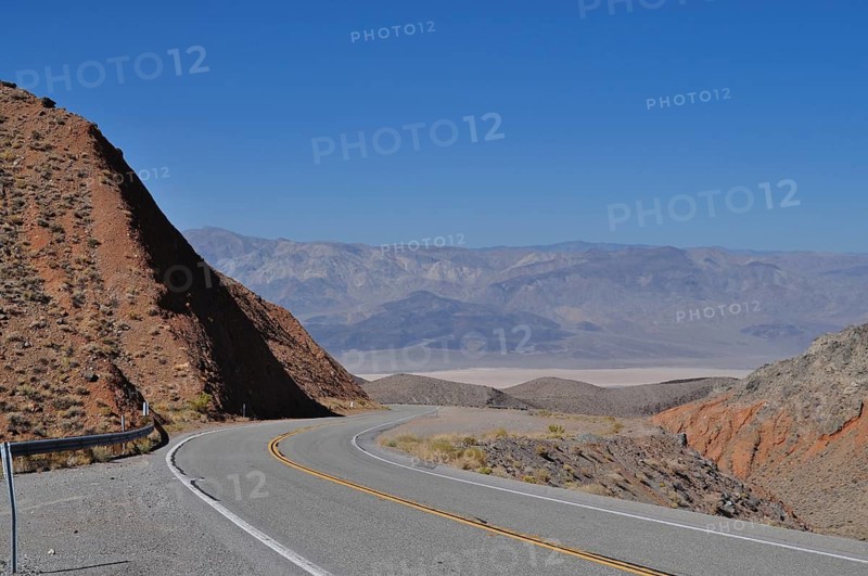 Road winds through barren, mountainous desert landscape, Death Valley National Park, Mojave Desert, California, Nevada, USA
