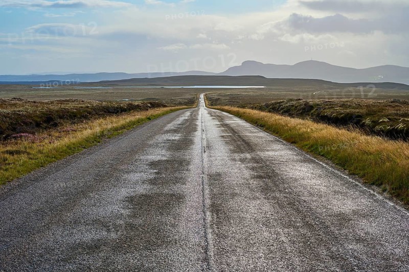 Endless road through vast countryside with distant mountains and dramatic skies, Tongue, Lairg, Scotland, United Kingdom, United Kingdom