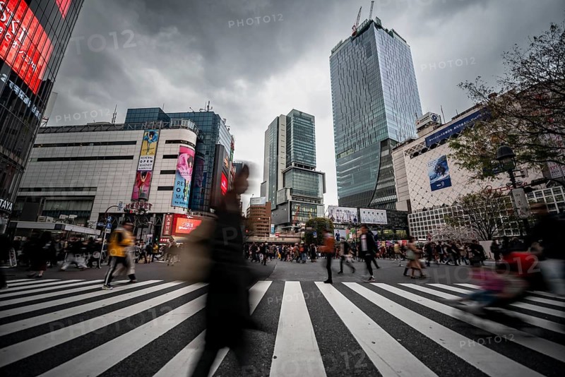 Crowd crossing zebra crossing on a large intersection, motion blur, back modern houses with colorful neon signs, long exposure, Shibuya Crossing, Shibuya, Tokyo, Japan