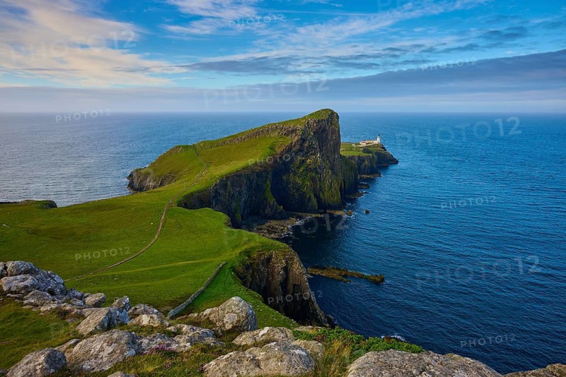 A far-reaching view of a coastline with a lighthouse and green cliffs, Neist Point Lighthouse, Waterstein, Isle of Skye, Scotland, United Kingdom, Great Britain