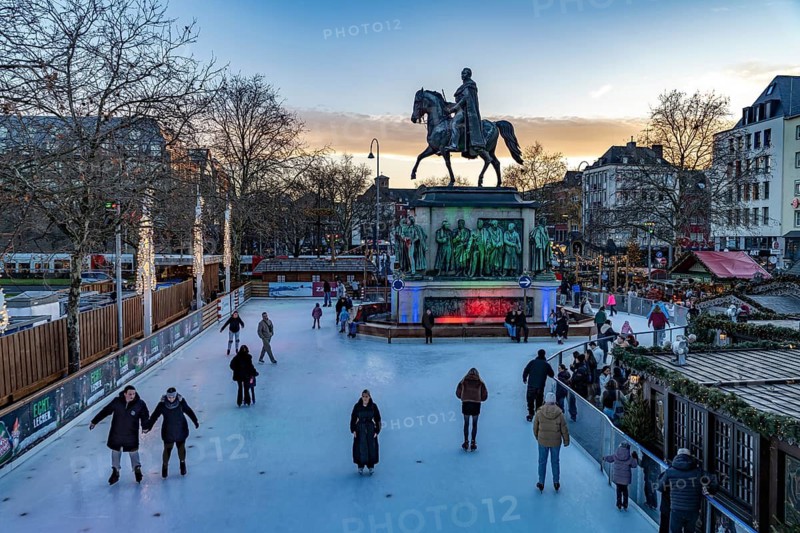 Christmas market Heinzel's winter fairy tale with the ice rink at Heumarkt and the equestrian monument to King Frederick William III of Prussia at dusk, Cologne, North Rhine-Westphalia, Germany