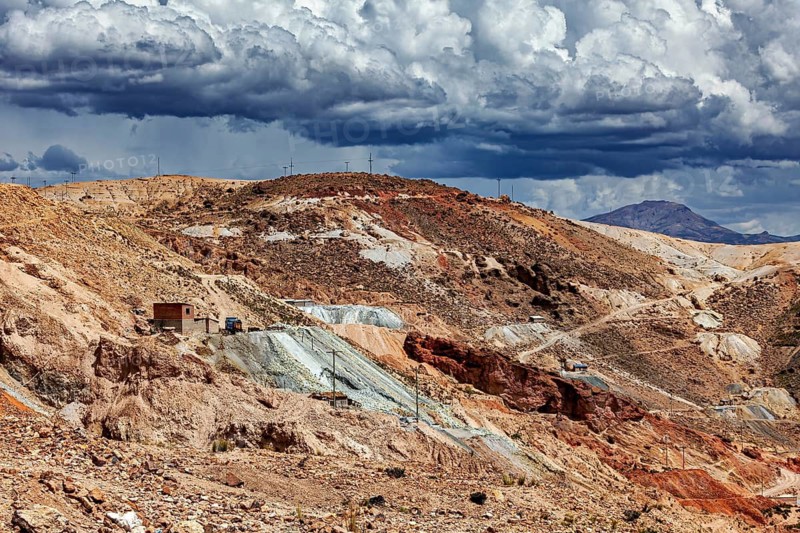 A dry hilly landscape with traces of mining activity under dramatic clouds, The silver mines near Potosi on Cerro Rico in Bolivia