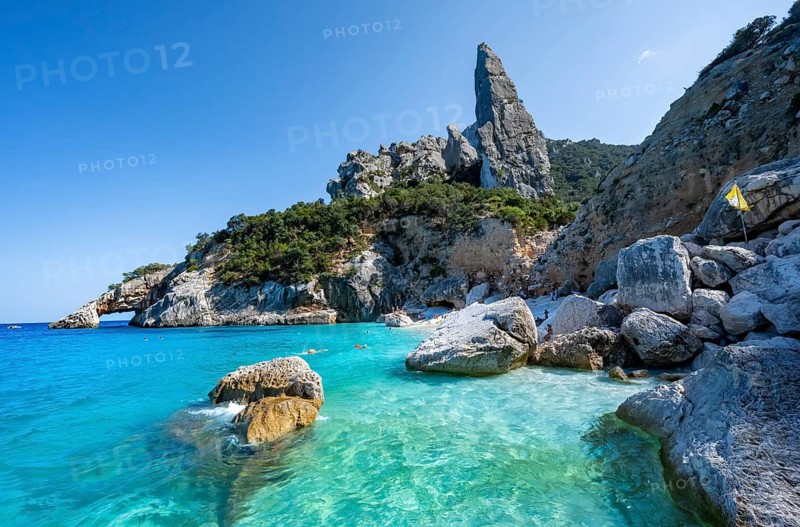 Light blue clear sea on a dream beach on Cala Goloritzé, picturesque rocky coast, steep coast with rock pin L'Aguglia, Golfo di Orosei, Baunei, Sardinia, Italy