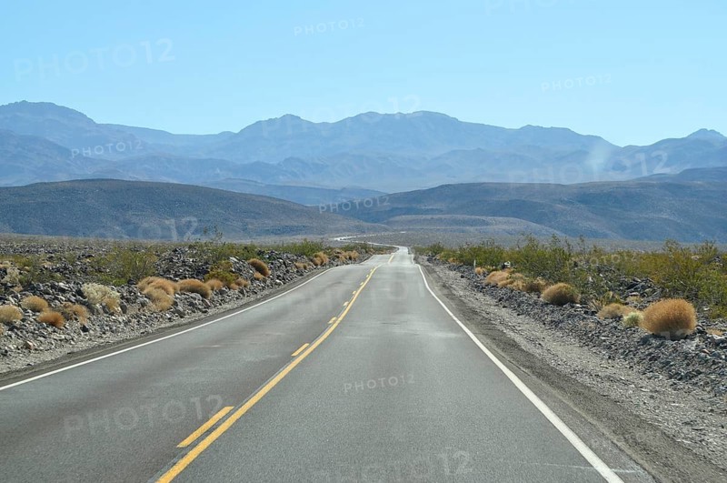 Empty road snakes through a distant desert landscape, Death Valley National Park, Mojave Desert, California, Nevada, USA
