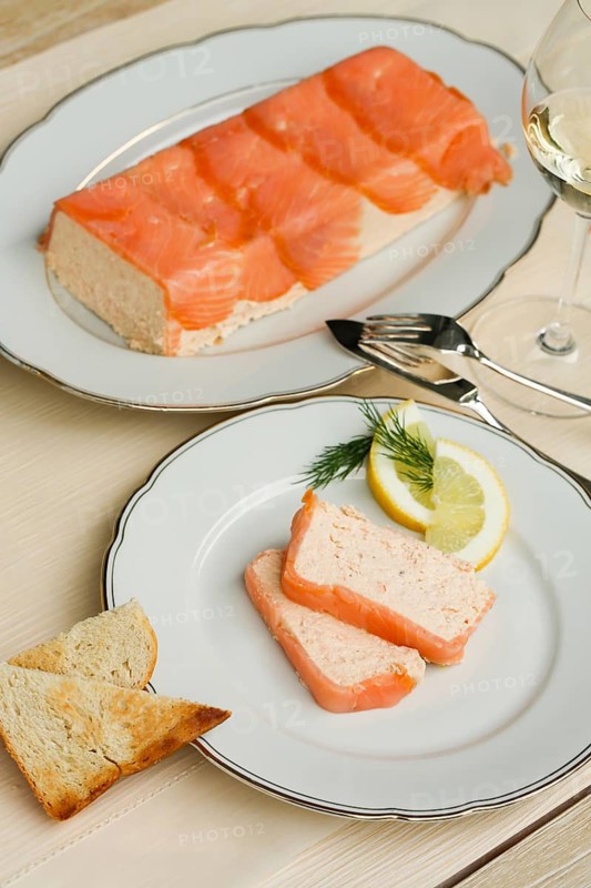 Southern German cuisine, salmon trout terrine arranged on a plate, salmon terrine with trout fillets, fish dish, salmon fillets, smoked salmon, starter, fine dining, Sunday crockery with gold rim, grandma's service, lemons, dill, fish cutlery, toast, food photography, studio, Germany