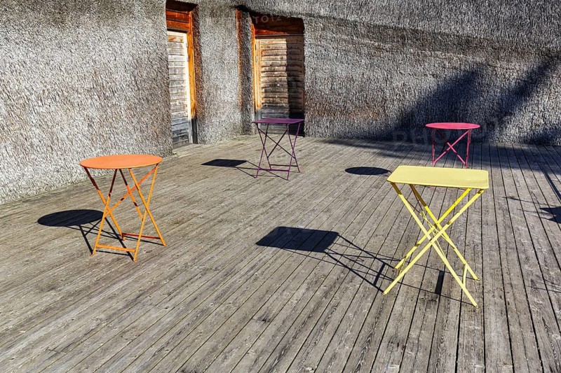 Different coloured folding tables, bistro tables on a wooden terrace, drop shadows, Naturum Takern Visitor Center, modern architecture, architect Gert Wingårdh, Vadstena, Östergötland, Sweden