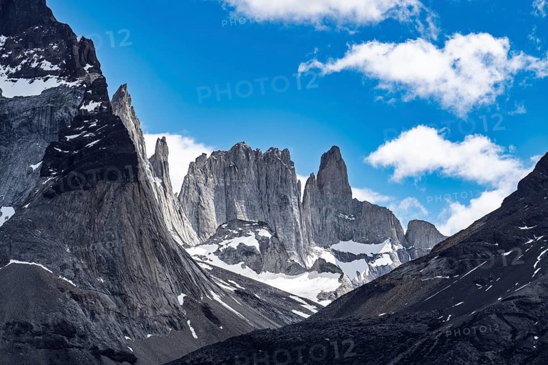 Granite peaks and rock towers of Cerro Catedral with snowfields under blue sky with clouds, Valle del Francés, Torres del Paine National Park, Magallanes region, Chile