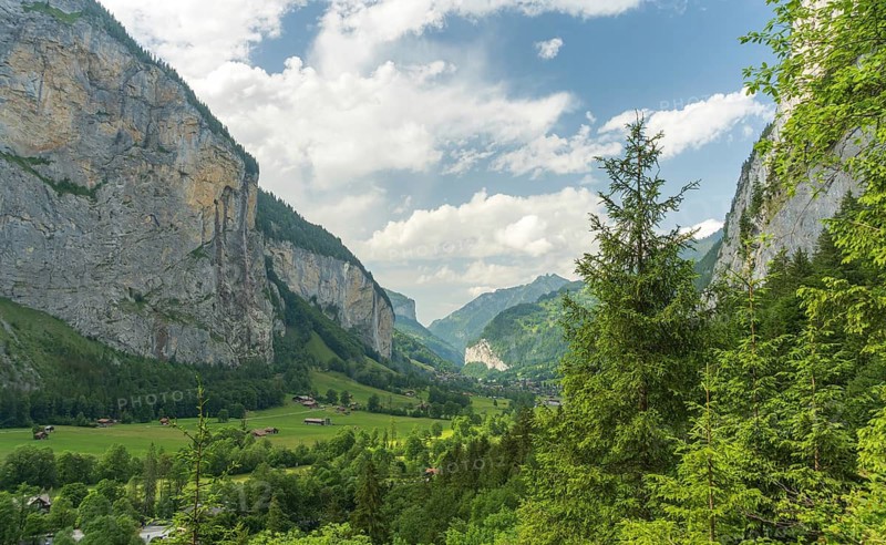Captivating landscape of Lauterbrunnen Valley, Switzerland, showcasing majestic cliffs, lush greenery, and rural charm under a vibrant sky