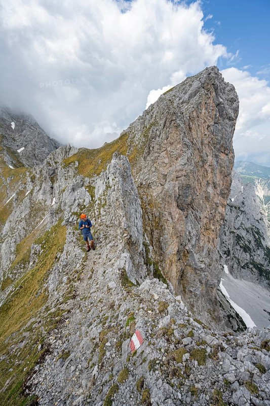 Mountaineers on a narrow hiking trail on a rocky ridge, ascent to the Maukspitze, clouds moving around the mountains, Wilder Kaiser, Kaiser Mountains, Tyrol, Austria