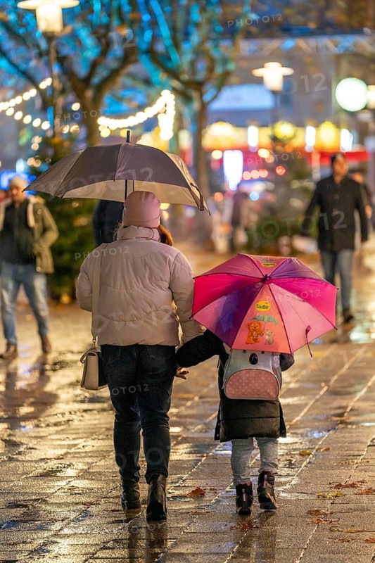 Rainy weather, passers-by with umbrellas, empty Christmas market, Essen, North Rhine-Westphalia, Germany