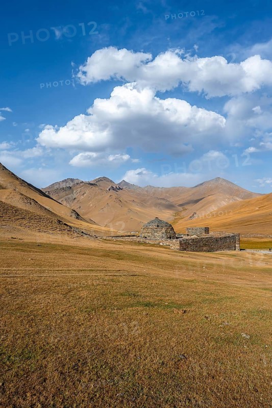 Historic caravanserai Tash Rabat from the 15th century, with yellow hills, Atbashy district in the Naryn region, Kyrgyzstan