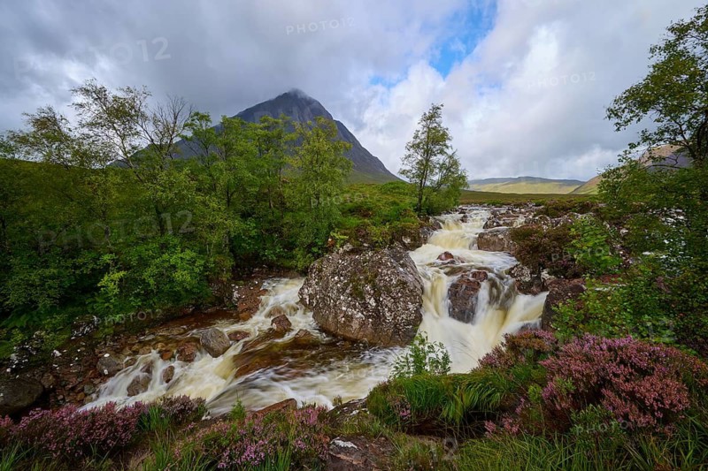 Fascinating landscape with waterfall in foreground and majestic mountain in background under cloudy sky, Buachaille Etive Mor Viewpoint, River Coupall, Glen Etive, Scotland, United Kingdom, Great Britain