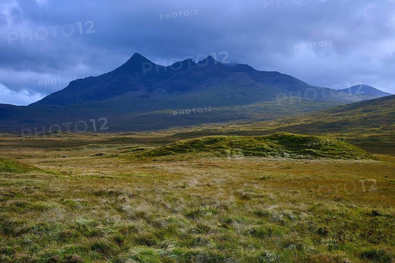 Rolling meadows in front of a massive mountain under dark clouds, Sligachan, Isle of Skye, Scotland, United Kingdom, United Kingdom