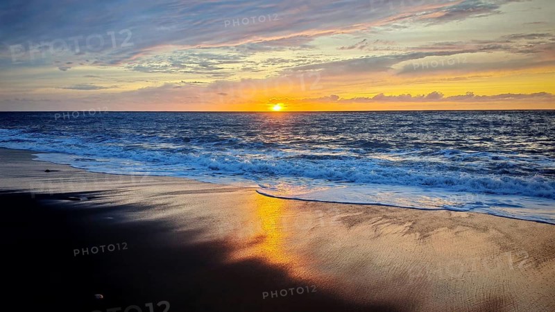 A beautiful sunset over the sea reflects colors on a quiet sandy beach, volcanic sand, hiking, Tarrafal de Monte Trigo, Santo Antao, Cabo Verde, Cape Verde, Cape Verde