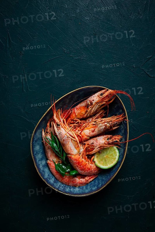 Langoustines, Australian, freshly frozen on ice, top view, lime and greens