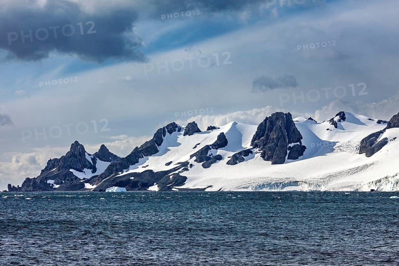 Snow-covered coastal mountains that stand out dramatically against the blue sky, The landscape in the Southern Ocean in Antarctica