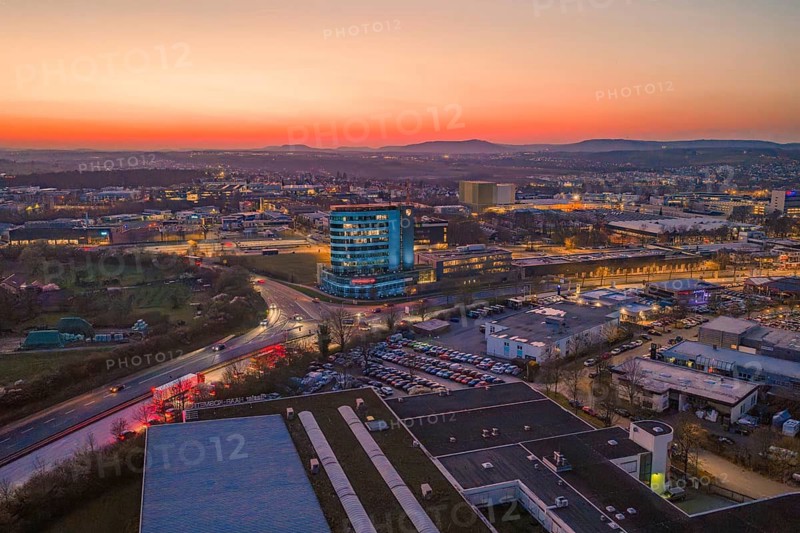 City panorama with a high-rise building at sunset and evening lights, Porsche, Bietigheim, Germany