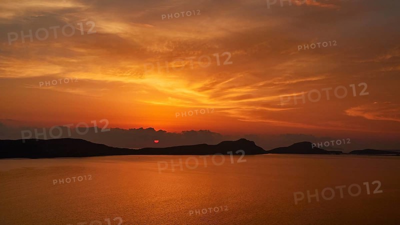 A bright orange sunset, clouds can be seen on the horizon, Navarino Bay, Pylos, Peloponnese, Greece