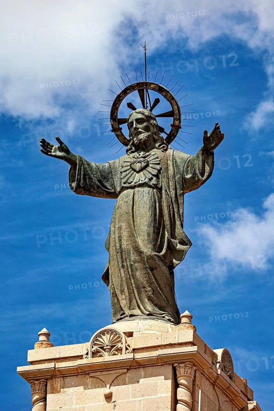 Large statue of Jesus with outstretched arms and halo against a blue sky, The Jesus statue of Potosi on Cerro Rico in Bolivia