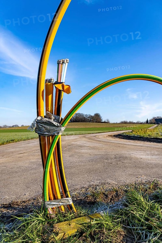 Fibre optic connection, empty conduits protrude from the ground along a dirt track, into which the actual fibre optic cable is later blown and connected to the respective house connection or distributor, provision of fast Internet in rural areas, in the south of Mülheim an der Ruhr, North Rhine-Westphalia, Germany