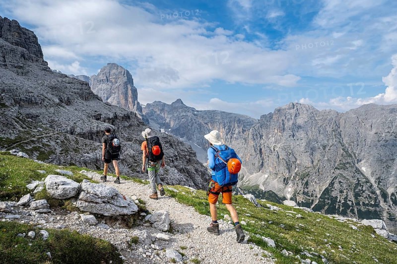 Three mountaineers on a hiking trail, rocky mountain landscape, Via Ferrata SOSAT via ferrata, Brenta Mountains, Trentino, Italy